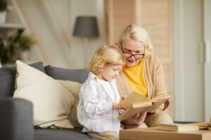 Senior woman looking at book with grandson